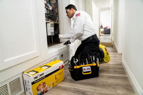 A One Hour Air Conditioning Tech working on a furnace inside a home's hallway in Melbourne FL