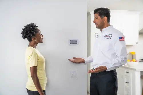 One Hour Air Conditioning & Heating tech speaking with homeowner explaining how her new thermostat works