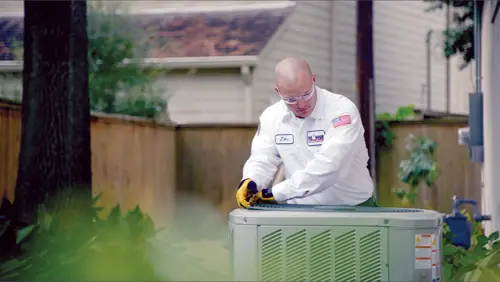 One Hour AC Tech working on removing the fan unit of an outside condenser at a Melbourne home