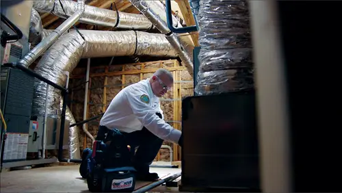 One Hour Air Conditioning Tech working in an attic at a home in Melbourne FL