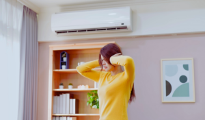 Woman holding ears because of noisy heat pump